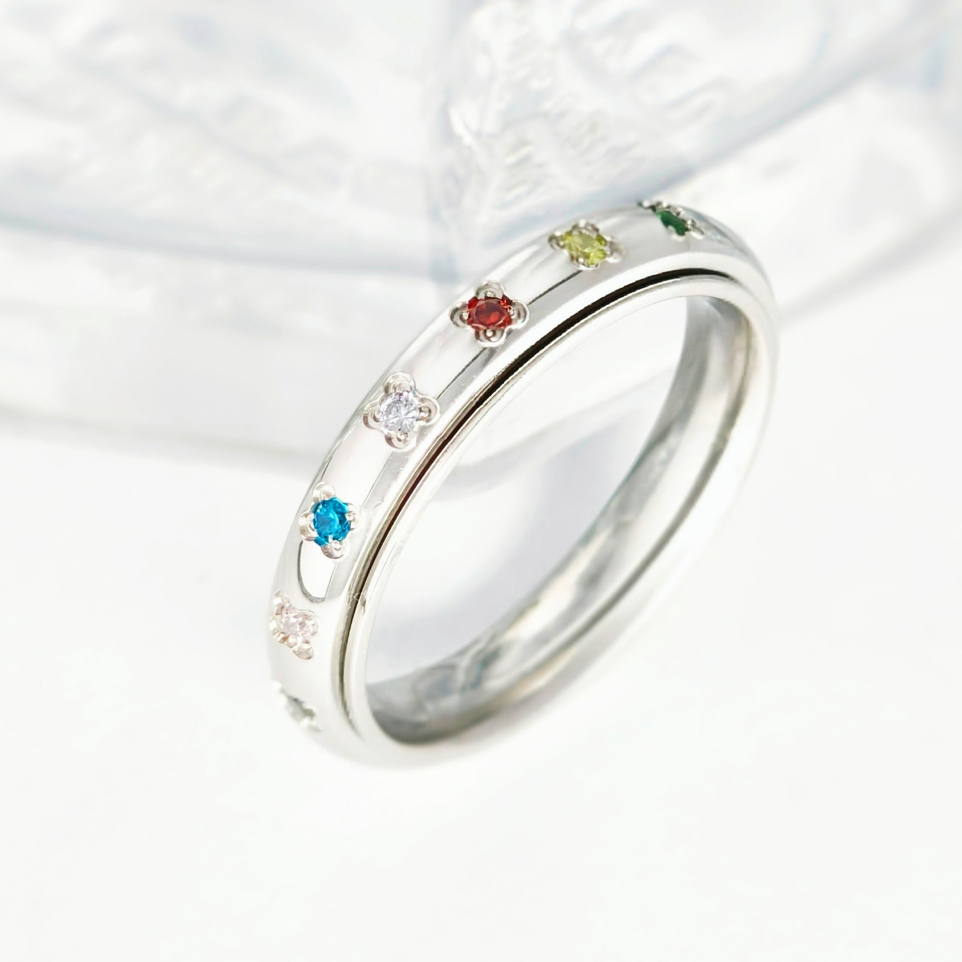 spinner ring with colorful gemstones on a white background