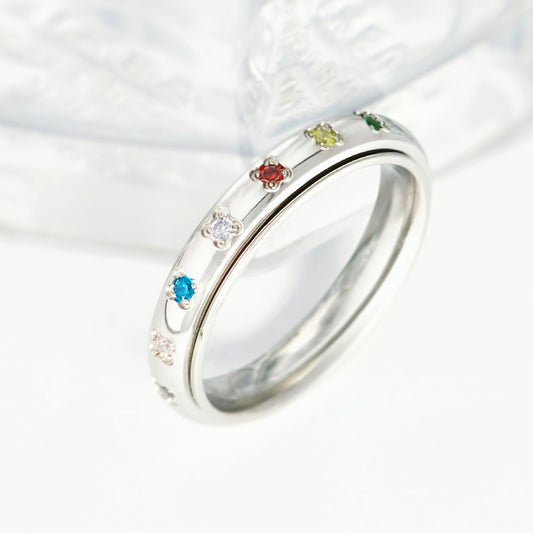 spinner ring with colorful gemstones on a white background