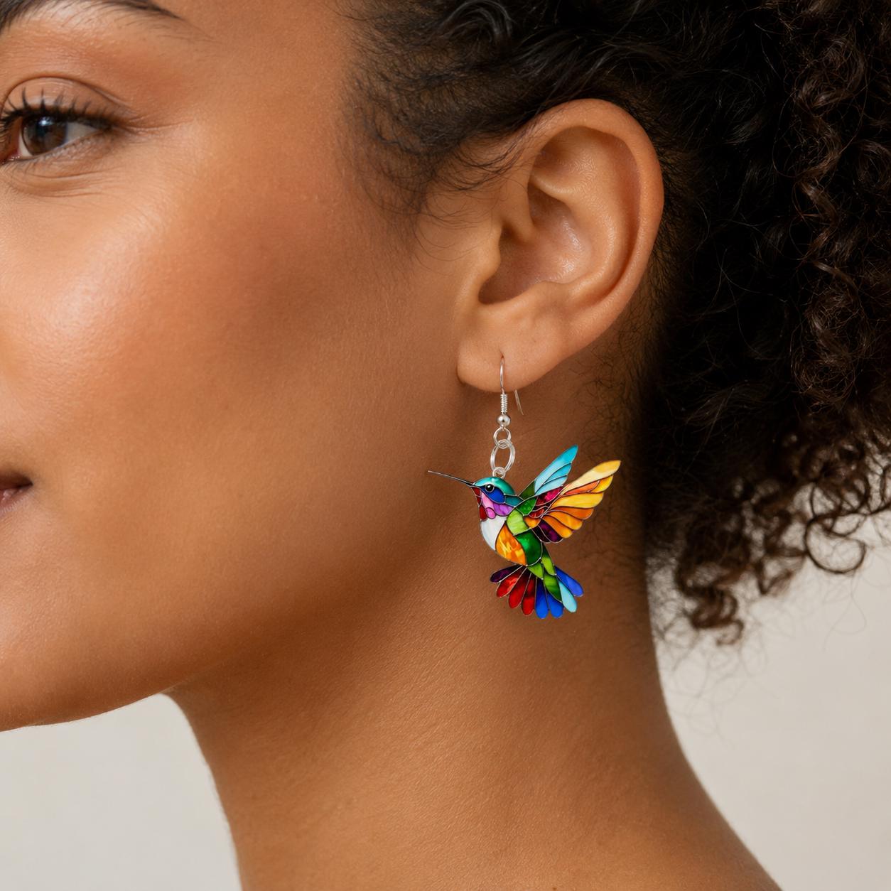 Hummingbird dangle earrings on neutral background