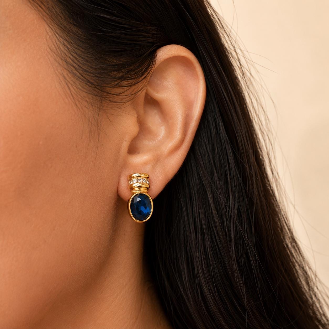 Blue glass gold oval stud earrings worn on model
