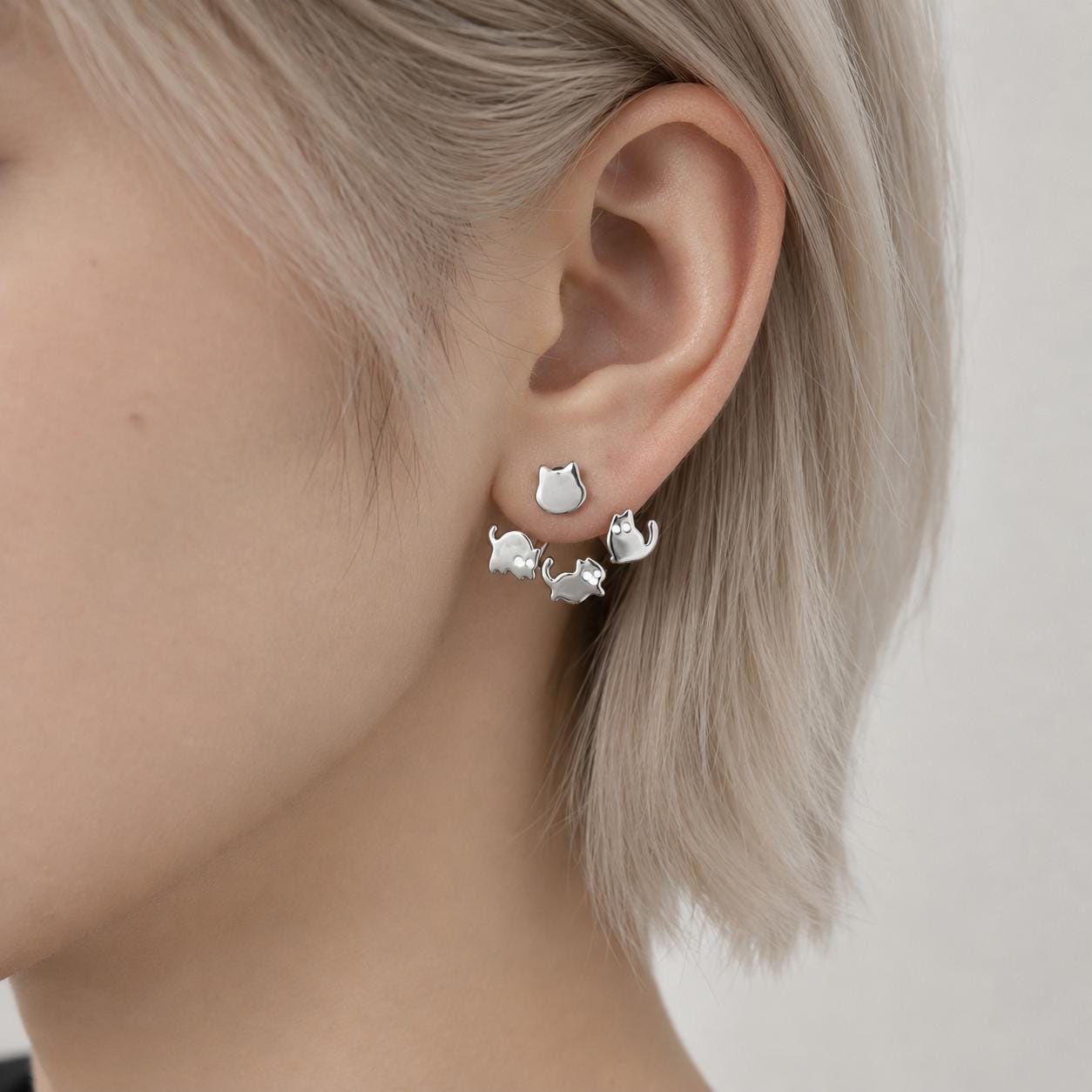 Cat ear jacket stud earrings on neutral background