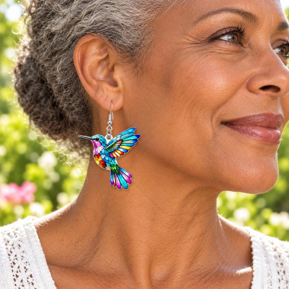 Colorful hummingbird earrings on neutral background