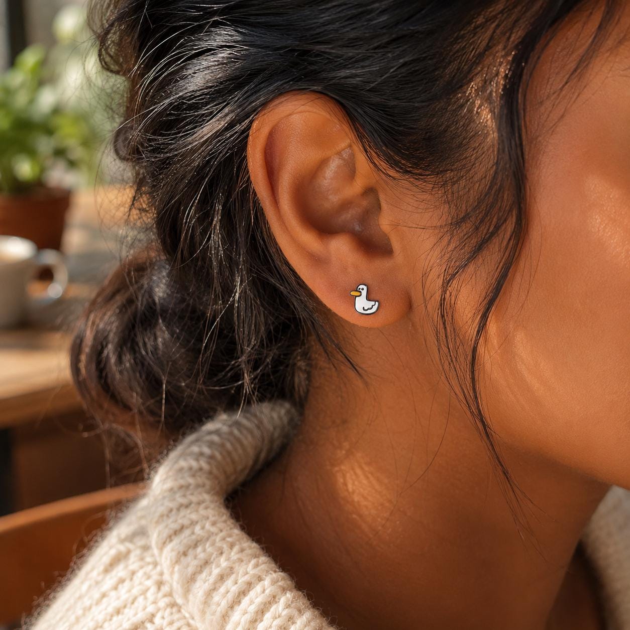 Duck stud earrings worn on model