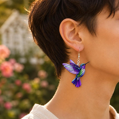 Purple hummingbird earrings on neutral background