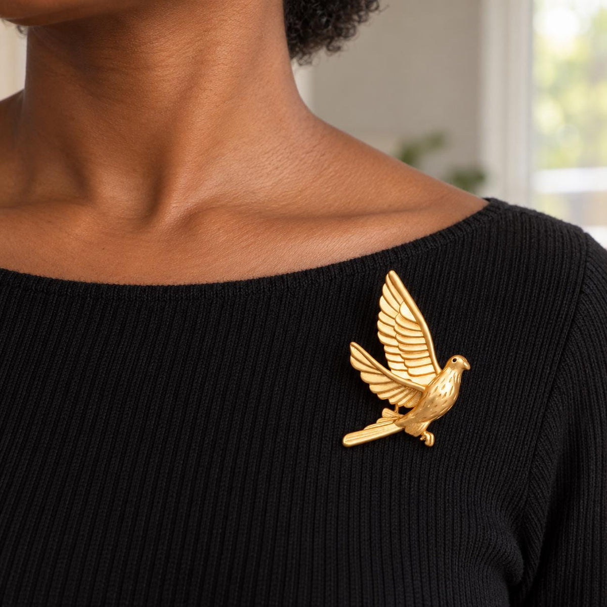 Brass dove brooch styled on a coat