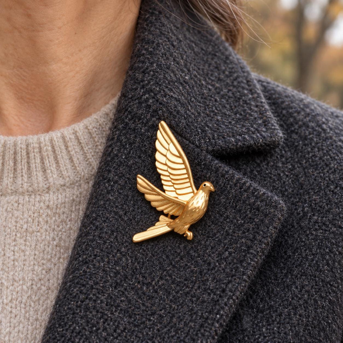 Brass dove brooch worn on a lapel